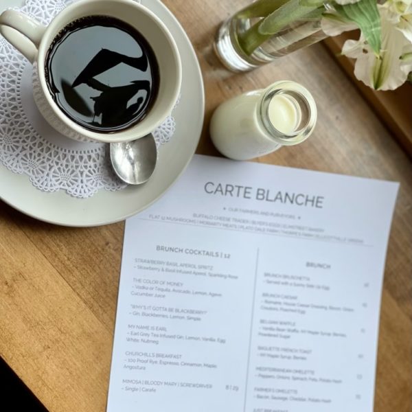 Coffee on a table with carte blanche menu